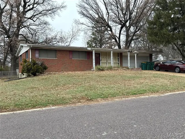 Ranch-style house with brick siding, an attached garage, and driveway