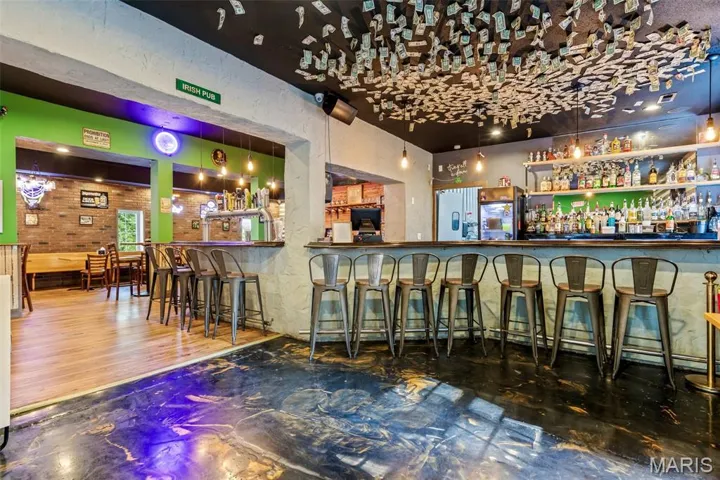 Community bar area featuring open shelves and dark countertops