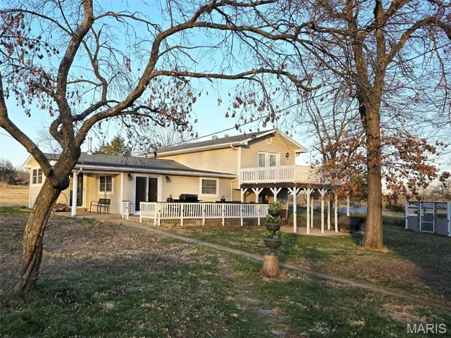 Rear view of property with a patio and a lawn