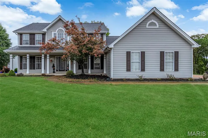 View of front of home featuring covered porch and a front lawn