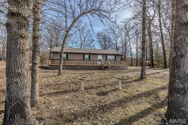 Ranch-style house featuring a wooden deck and new roof with shingles