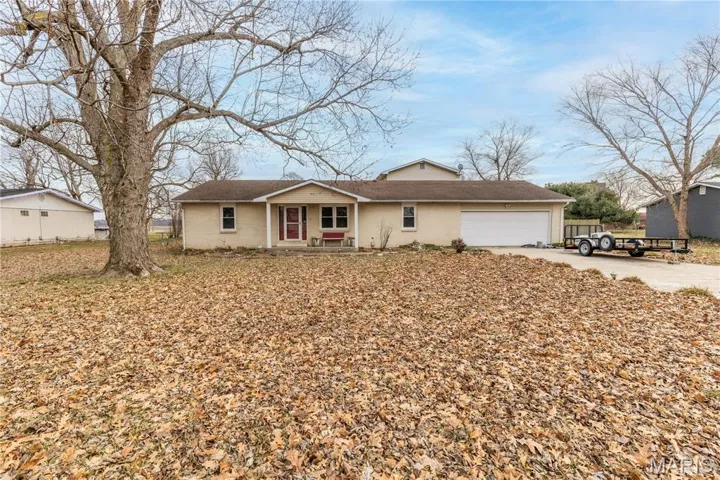 Ranch-style house with concrete driveway, an attached garage, a porch, and roof with shingles
