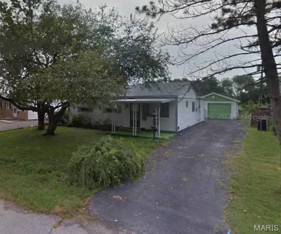 Bungalow featuring an outdoor structure, a garage, a front lawn, driveway, and covered porch