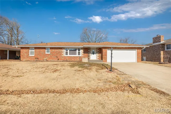 Single story home with brick siding, driveway, and a garage