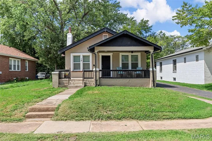 Bungalow with stucco siding, a front yard, covered porch, a chimney, and ceiling fan