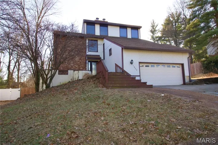 Traditional home with concrete driveway, a garage, and roof with shingles