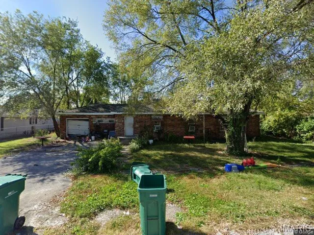 Ranch-style home with a front yard, driveway, brick siding, and a garage