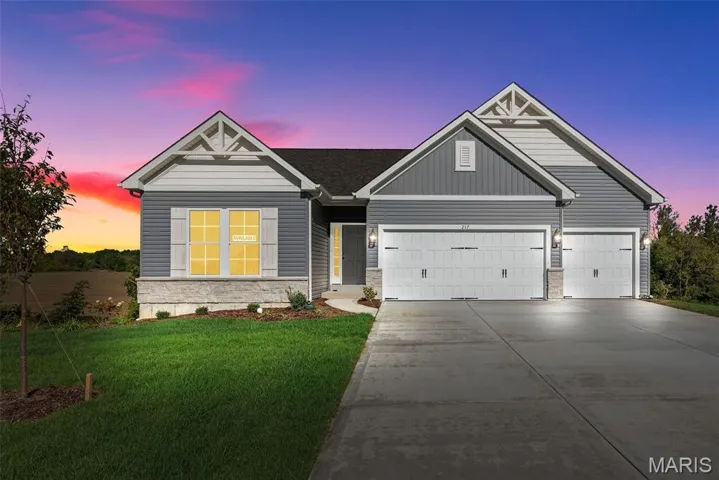 View of front facade with stone siding, concrete driveway, a front yard, and a garage