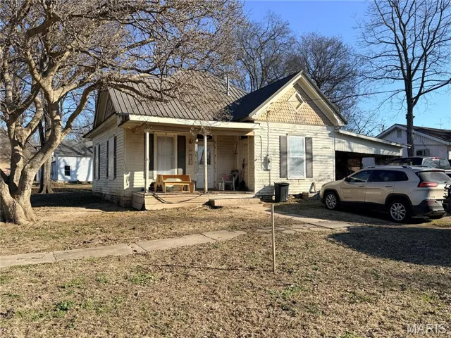View of front of home with covered porch and a metal roof