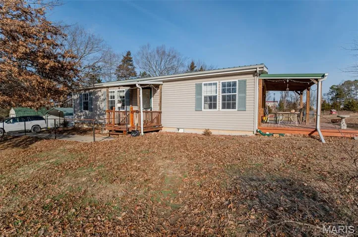 View of front of house featuring a wooden deck, a carport, and crawl space