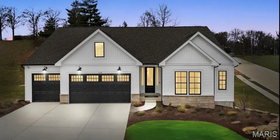 Modern farmhouse style home with stone siding, a shingled roof, and board and batten siding