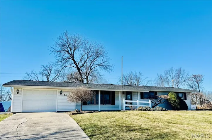 Ranch-style home with concrete driveway, a garage, a front lawn, and a porch