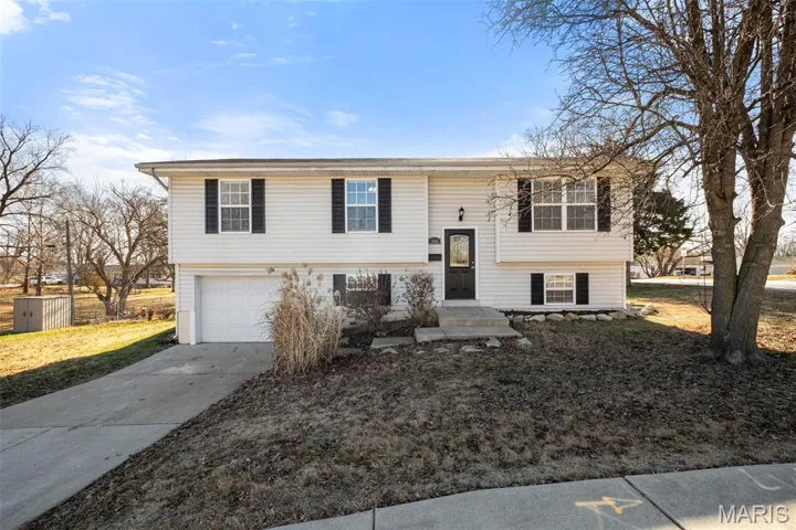 Bi-level home with concrete driveway and a garage