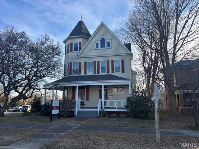 Victorian home with covered porch and a shingled roof