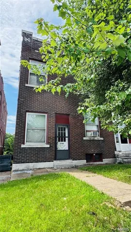 View of front of home featuring brick siding and a front lawn