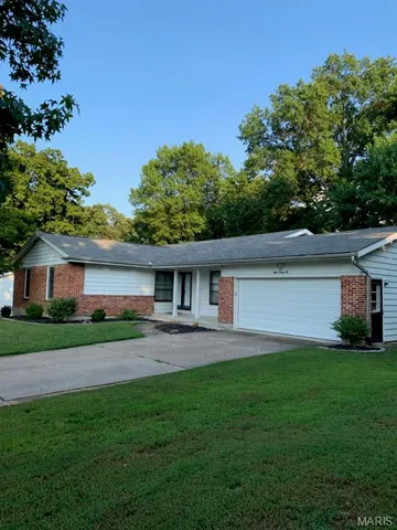 Ranch-style house with concrete driveway, a front lawn, brick siding, and a garage