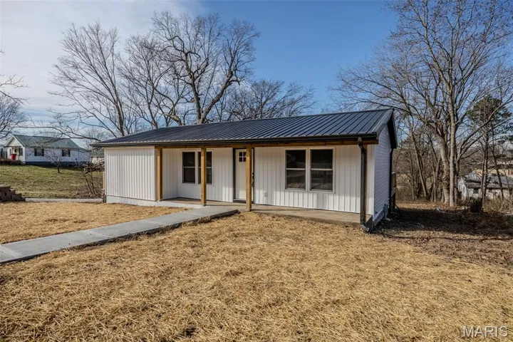View of front of property with covered porch and a metal roof