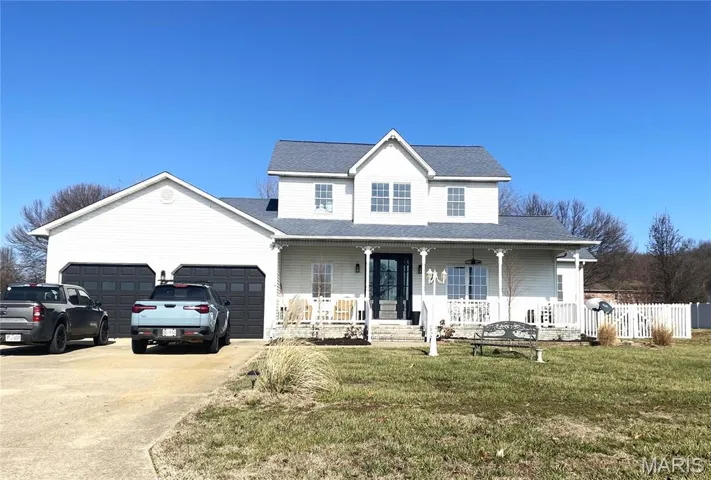 View of front of property featuring covered porch, concrete driveway, roof with shingles, and an attached garage