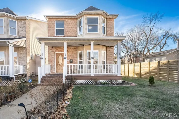 View of front of house featuring brick siding and a porch