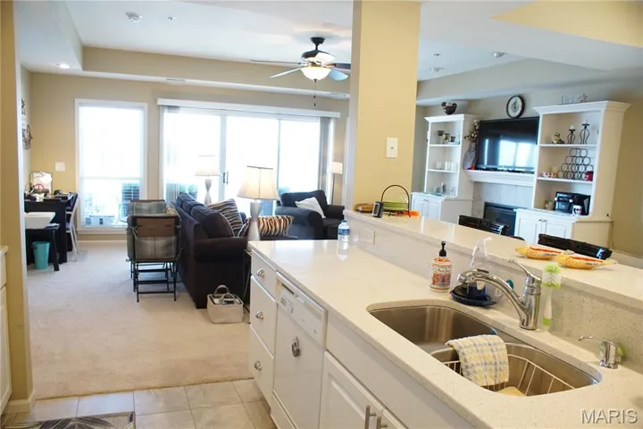 Kitchen with white cabinets, light stone countertops, open floor plan, white dishwasher, and recessed lighting