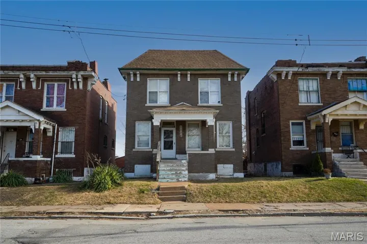 View of front facade featuring brick siding and a front lawn