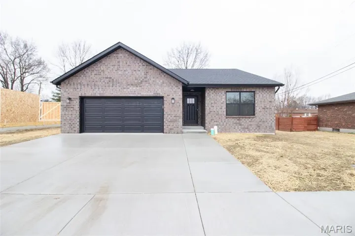 Single story home with driveway, brick siding, a garage, and roof with shingles