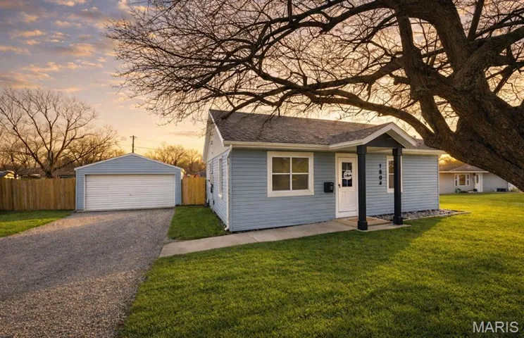 Bungalow-style house featuring an outbuilding, a detached garage, and a shingled roof