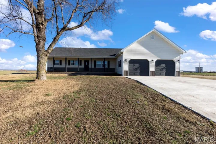Single story home with a porch, concrete driveway, a front yard, and an attached garage