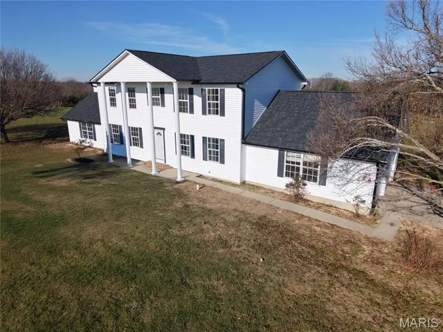 View of front of home featuring roof with shingles and a front lawn