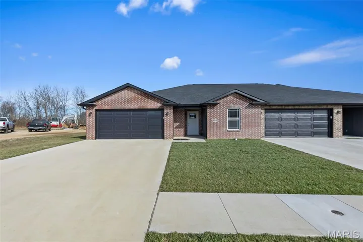 Single story home with brick siding, a front lawn, concrete driveway, and a shingled roof