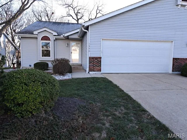 Ranch-style home featuring brick siding, concrete driveway, a shingled roof, and a garage
