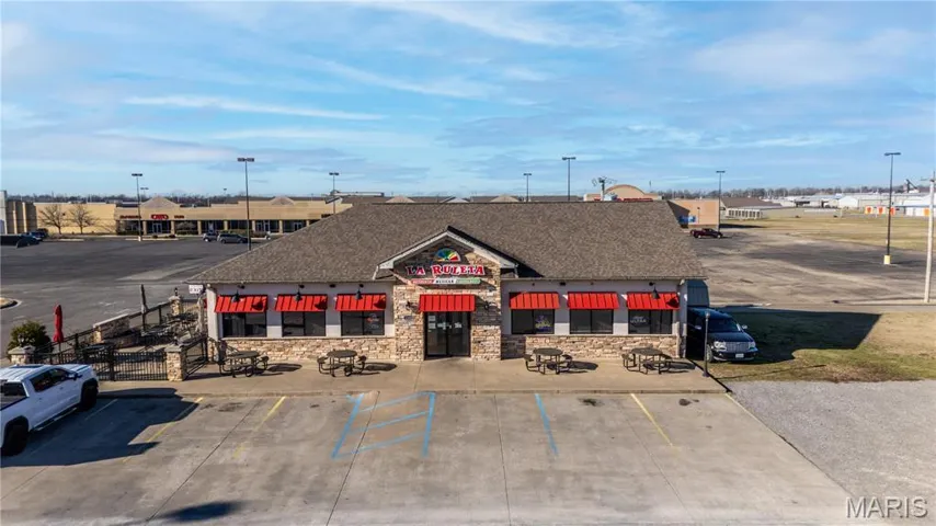 View of commercial property with uncovered parking