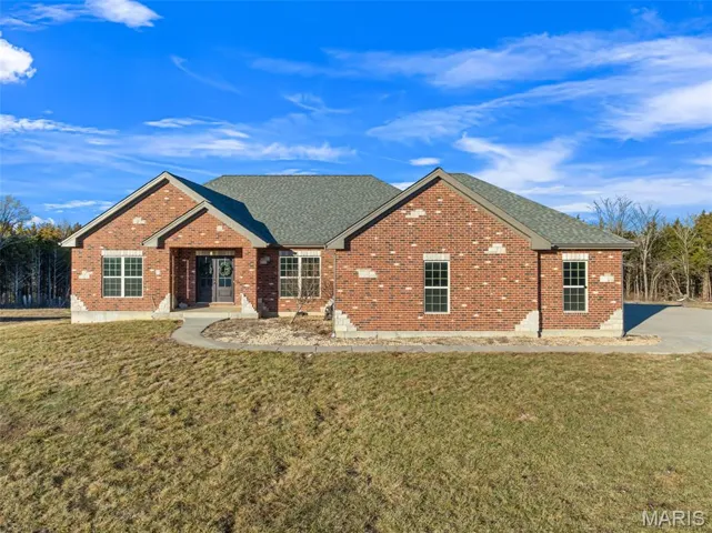 Ranch-style home with brick siding, a front yard, and a shingled roof