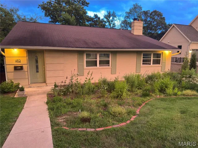 View of front facade featuring a front lawn and a chimney
