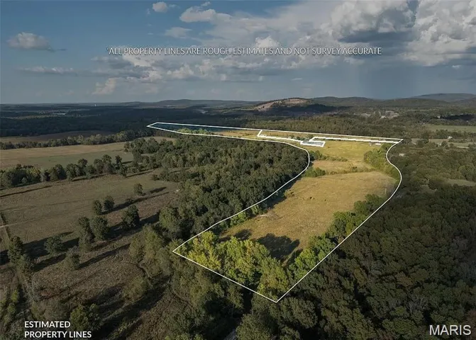 Aerial view of property's location with property parcel outlined and a mountain backdrop