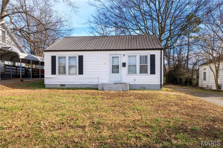 View of front of home featuring crawl space, a metal roof, a front yard, and a carport