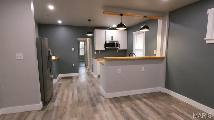 Kitchen with white cabinetry, light countertops, recessed lighting, appliances with stainless steel finishes, and pendant lighting