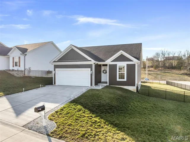Single story home with concrete driveway, a shingled roof, and a garage