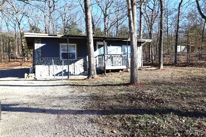 View of front of home with a deck and stone siding