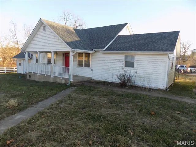 View of front of property featuring a porch and roof with shingles