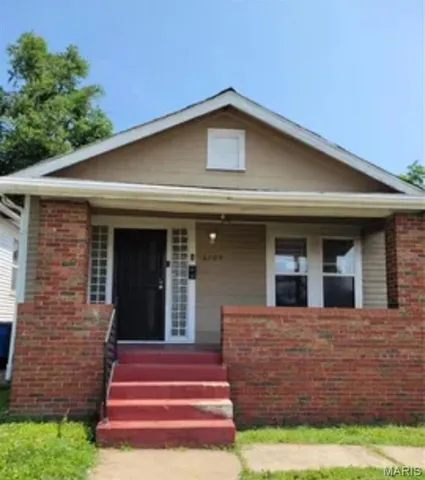 View of front facade with a porch and brick siding