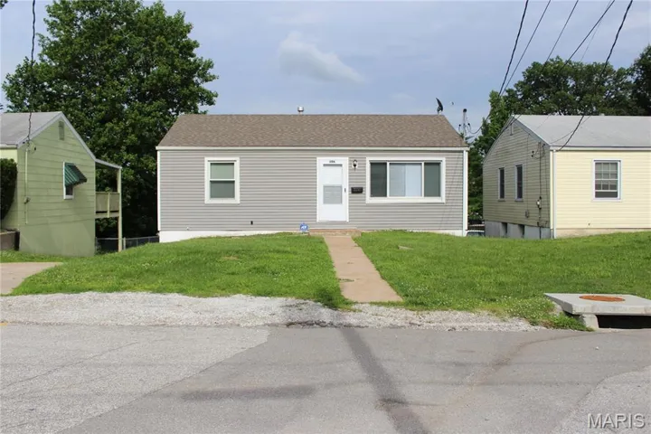 View of front of house with a front lawn and roof with shingles