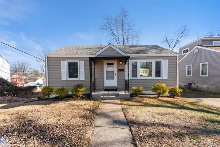 Bungalow with a shingled roof and a front lawn