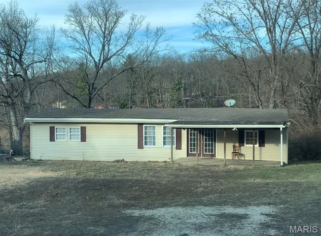 Single story home with covered porch and a front yard