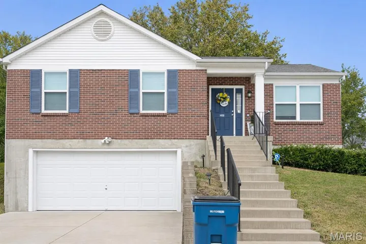 Ranch-style home with concrete driveway, brick siding, and a garage