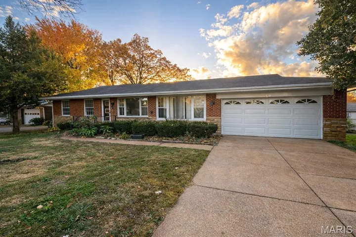 Ranch-style house featuring a front lawn, covered porch, a garage, concrete driveway, and brick siding