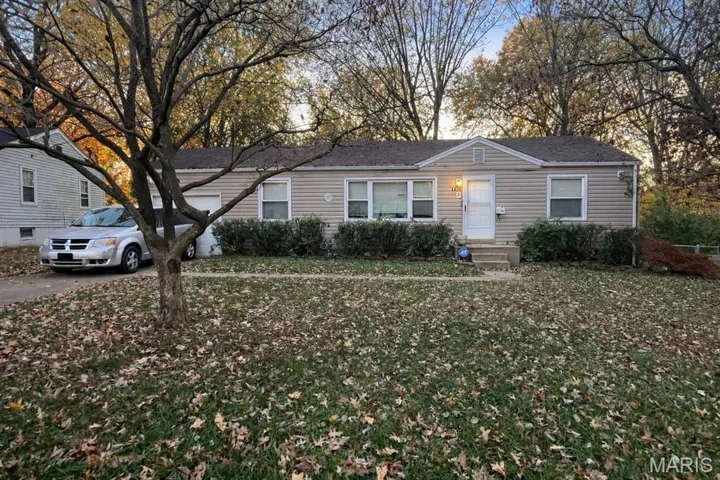 View of front of house with a shingled roof and a front lawn