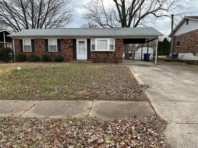 Ranch-style house with brick siding, concrete driveway, an attached carport, and a front lawn