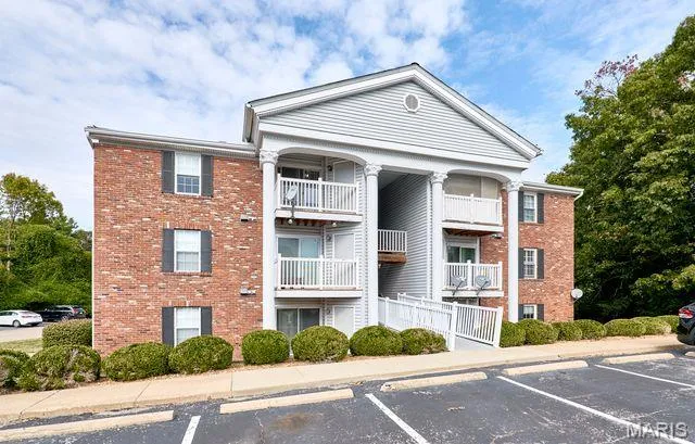View of building exterior with uncovered parking