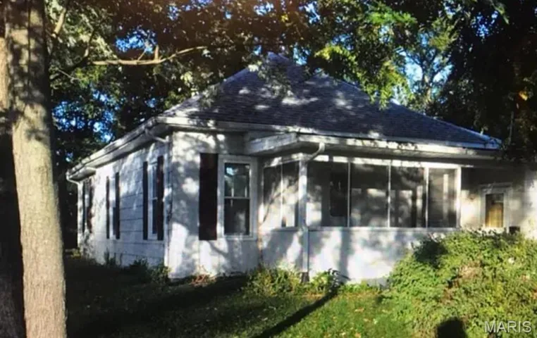 View of property exterior with a sunroom and roof with shingles